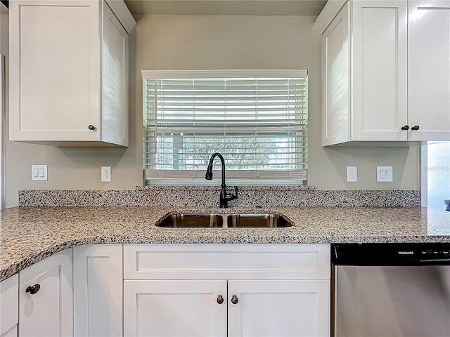 14243 County Road 450, Umatilla, FL 32784 - kitchen with stainless steel dishwasher, white cabinetry, and light stone countertops