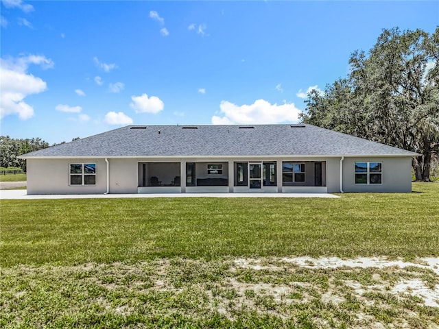 14243 County Road 450, Umatilla, FL 32784 - back of house featuring a lawn, stucco siding, a sunroom, and roof with shingles