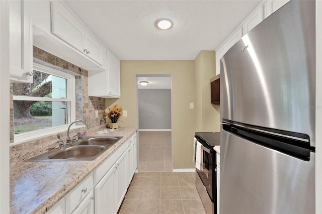 1506 S Elliott St, Sanford, FL 32771 - kitchen with appliances with stainless steel finishes, white cabinetry, light tile patterned flooring, and backsplash