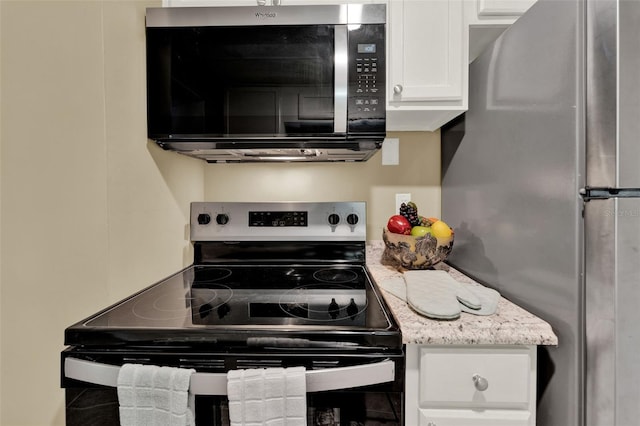 1506 S Elliott St, Sanford, FL 32771 - kitchen featuring stainless steel appliances, white cabinetry, and light stone counters
