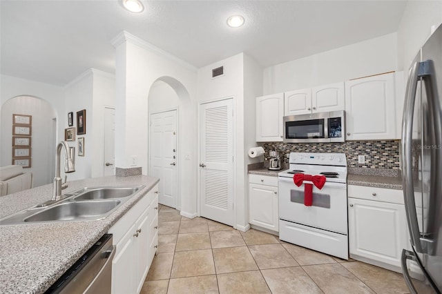 860 N Orange Ave Unit 210, Orlando, FL 32801 - kitchen featuring appliances with stainless steel finishes, tasteful backsplash, arched walkways, white cabinets, and recessed lighting