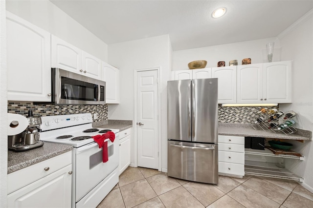 860 N Orange Ave Unit 210, Orlando, FL 32801 - kitchen with appliances with stainless steel finishes, decorative backsplash, white cabinetry, and light tile patterned flooring