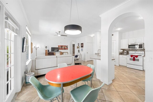860 N Orange Ave Unit 210, Orlando, FL 32801 - dining space featuring arched walkways, light tile patterned flooring, and ornamental molding