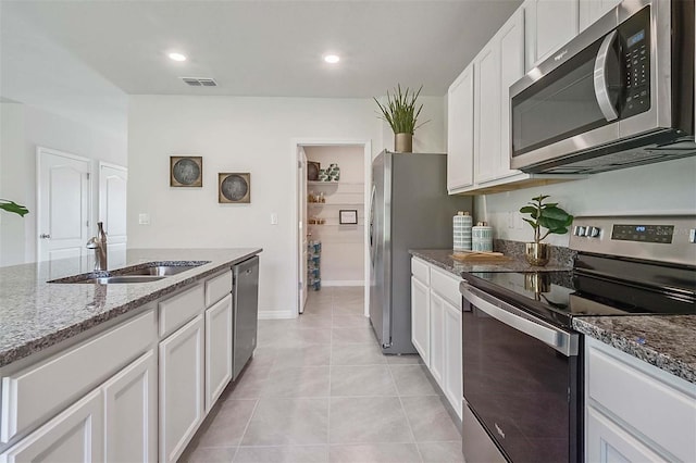 5157 Masser Rd, Saint Cloud, FL 34772 - kitchen featuring stainless steel appliances, dark stone countertops, white cabinets, and recessed lighting