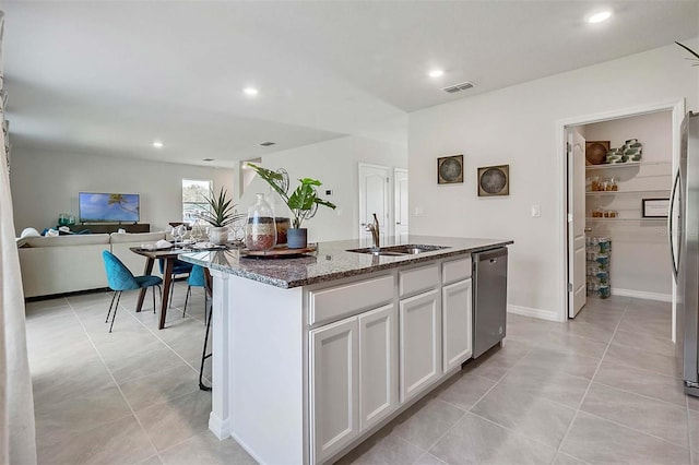 5157 Masser Rd, Saint Cloud, FL 34772 - kitchen featuring appliances with stainless steel finishes, dark stone countertops, a center island with sink, white cabinetry, and recessed lighting