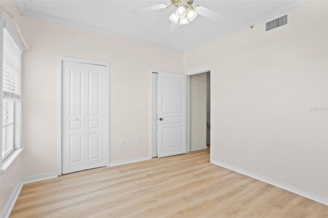 660 Celebration Ave Unit 250, Kissimmee, FL 34747 - unfurnished bedroom featuring light wood-style floors, crown molding, multiple closets, and a ceiling fan
