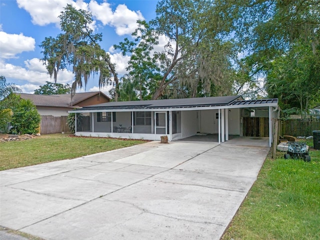 235 Ruth Blvd, Longwood, FL 32750 - ranch-style house featuring a sunroom, concrete driveway, a carport, and a metal roof
