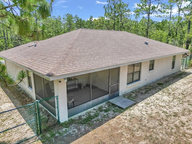 7120 N Glenridge Cir, Citrus Springs, FL 34434 - back of house with a sunroom, a shingled roof, a gate, and stucco siding