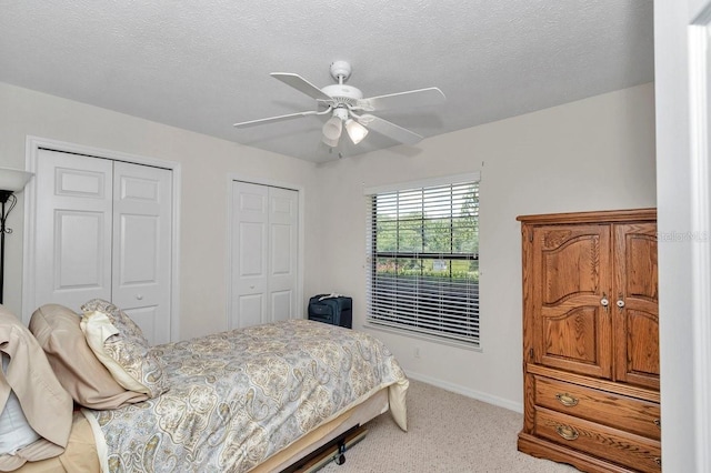 7120 N Glenridge Cir, Citrus Springs, FL 34434 - bedroom featuring two closets, light colored carpet, ceiling fan, and a textured ceiling