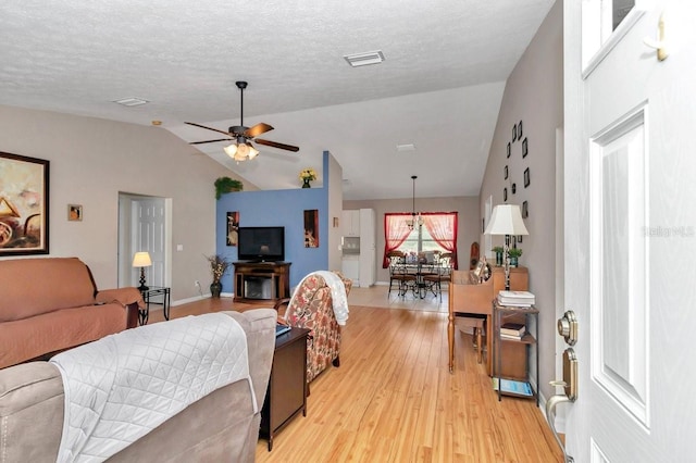7120 N Glenridge Cir, Citrus Springs, FL 34434 - living room with light wood-style flooring, vaulted ceiling, ceiling fan, and a textured ceiling