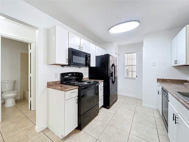645 Stafford Ter Unit 163, Altamonte Springs, FL 32714 - kitchen with black appliances, light tile patterned floors, white cabinets, and dark countertops