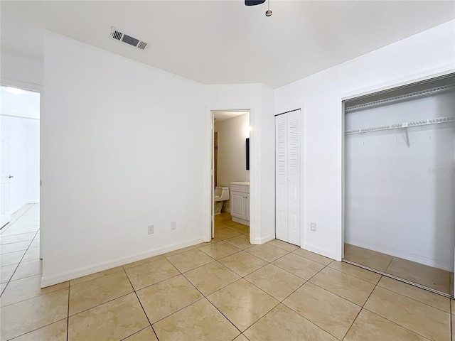 645 Stafford Ter Unit 163, Altamonte Springs, FL 32714 - unfurnished bedroom featuring multiple closets, light tile patterned floors, and connected bathroom
