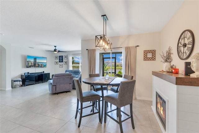 633 Greymount St, Davenport, FL 33837 - dining room featuring light tile patterned floors, a glass covered fireplace, and a ceiling fan