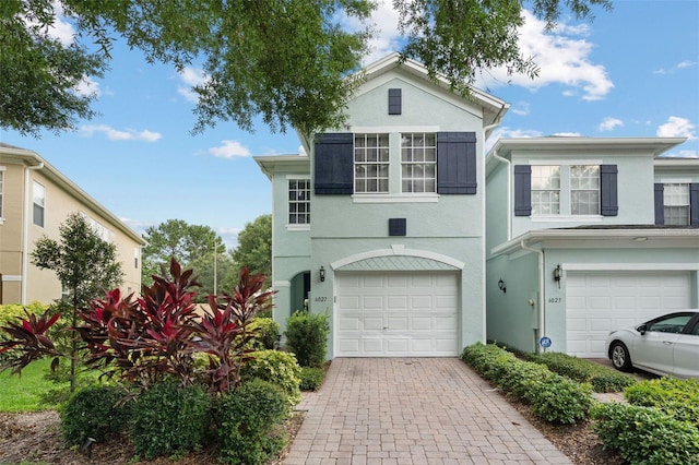 6027 Strada Isle Way, Orlando, FL 32835 - view of front facade with stucco siding, a garage, and driveway