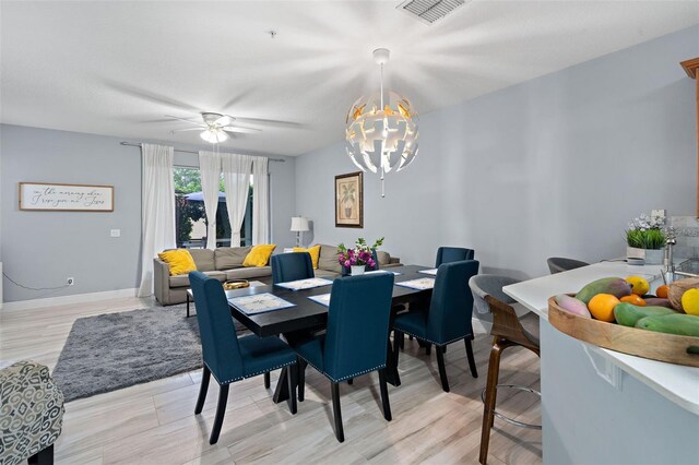 6027 Strada Isle Way, Orlando, FL 32835 - dining area with a chandelier, ceiling fan, and light wood-style floors