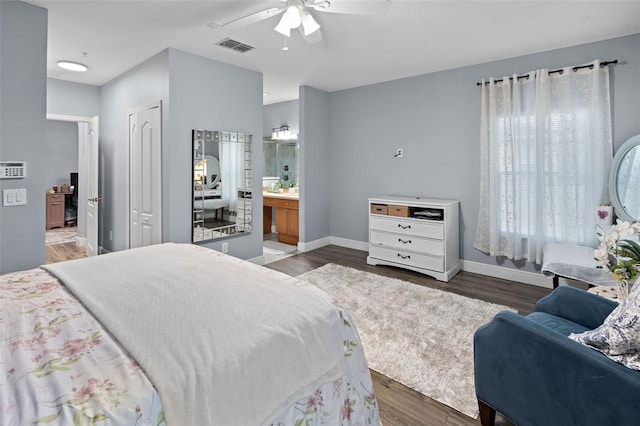 6027 Strada Isle Way, Orlando, FL 32835 - bedroom featuring wood finished floors, connected bathroom, multiple windows, and ceiling fan