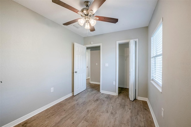 4559 W Gore Ave, Orlando, FL 32811 - unfurnished bedroom with multiple windows, light wood-style floors, a closet, and ceiling fan