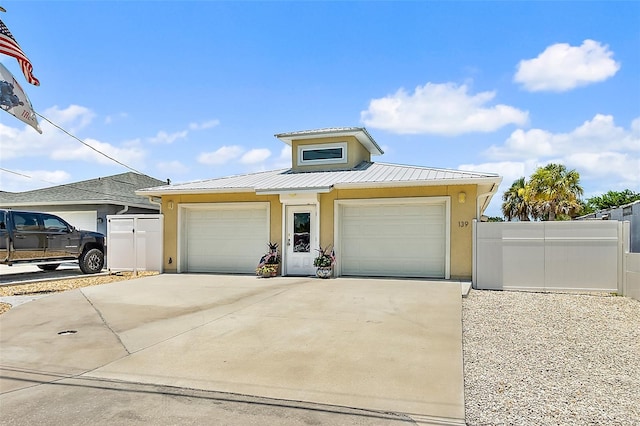 139 Douglas St, Edgewater, FL 32141 - view of front facade with stucco siding, a garage, a metal roof, and concrete driveway