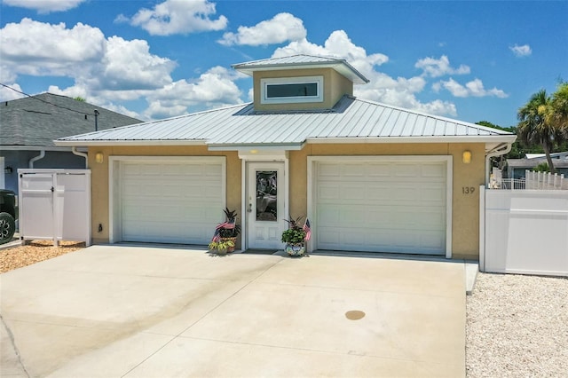 139 Douglas St, Edgewater, FL 32141 - view of front facade featuring stucco siding, driveway, a metal roof, and a garage