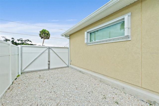 139 Douglas St, Edgewater, FL 32141 - view of side of property with a gate and stucco siding