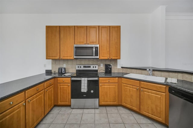 506 Mirasol Cir Unit 202, Celebration, FL 34747 - kitchen featuring appliances with stainless steel finishes, dark countertops, tasteful backsplash, and light tile patterned floors