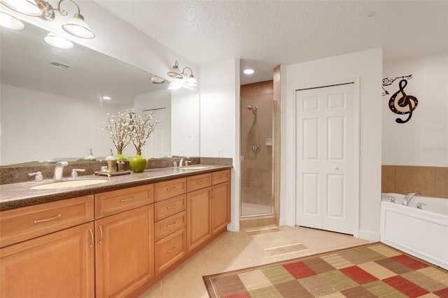 6336 Buford St Unit 209, Orlando, FL 32835 - bathroom with tile patterned flooring, double vanity, a shower stall, a garden tub, and a textured ceiling
