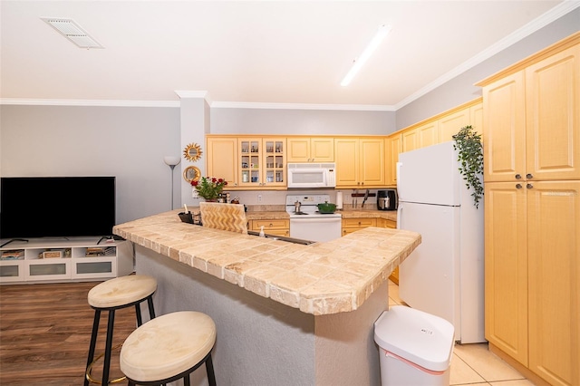 3707 Conroy Rd Unit 1715, Orlando, FL 32839 - kitchen featuring white appliances, a kitchen bar, ornamental molding, and glass insert cabinets
