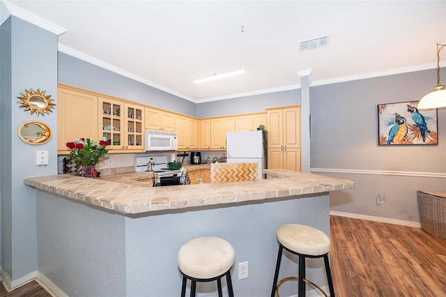 3707 Conroy Rd Unit 1715, Orlando, FL 32839 - kitchen featuring white appliances, a kitchen bar, a peninsula, dark wood finished floors, and glass insert cabinets
