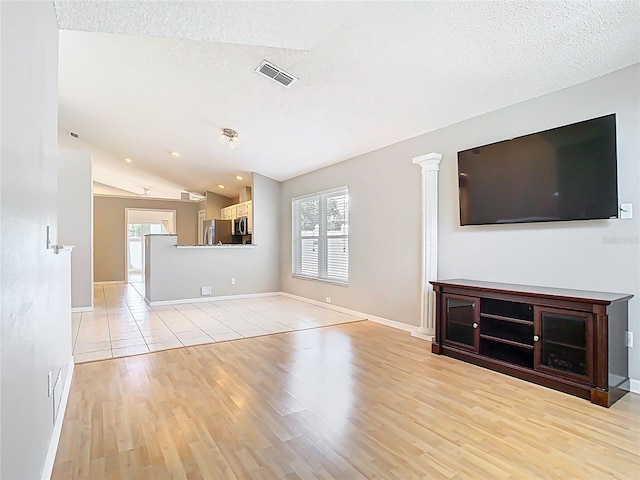 2641 Delcrest Dr, Orlando, FL 32817 - unfurnished living room with healthy amount of natural light, light wood finished floors, vaulted ceiling, and a textured ceiling
