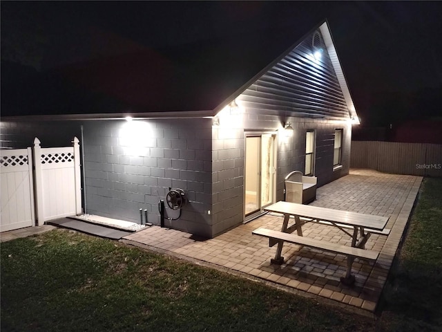 2641 Delcrest Dr, Orlando, FL 32817 - back of house at night featuring a patio and concrete block siding