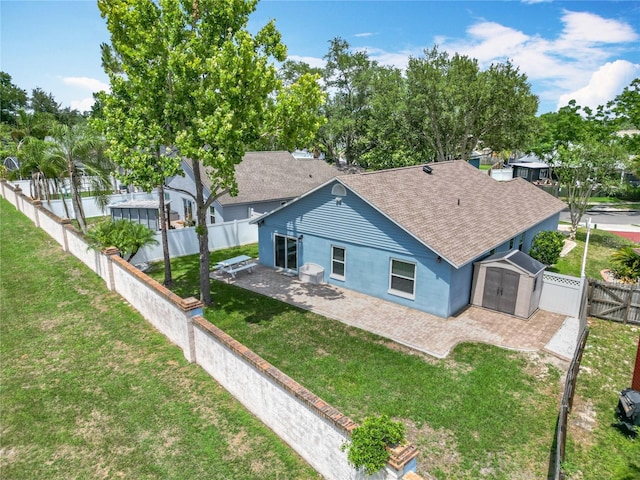 2641 Delcrest Dr, Orlando, FL 32817 - back of house with roof with shingles, a storage shed, a fenced backyard, a patio area, and stucco siding