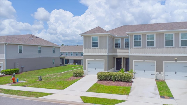 275 Blueberry Ln, Davenport, FL 33837 - townhome / multi-family property featuring a front lawn, driveway, board and batten siding, and an attached garage
