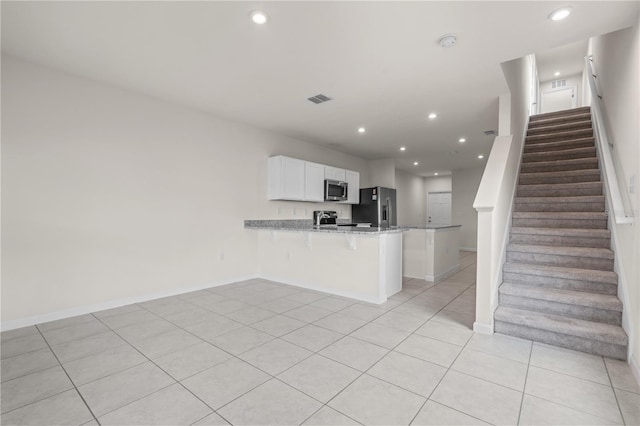 275 Blueberry Ln, Davenport, FL 33837 - kitchen with stainless steel appliances, a peninsula, recessed lighting, light stone countertops, and light tile patterned floors