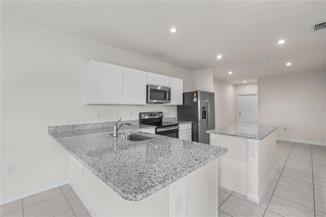 275 Blueberry Ln, Davenport, FL 33837 - kitchen featuring appliances with stainless steel finishes, a center island, recessed lighting, light tile patterned flooring, and white cabinetry