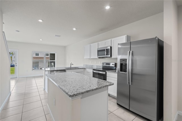 275 Blueberry Ln, Davenport, FL 33837 - kitchen featuring stainless steel appliances, a peninsula, light tile patterned flooring, white cabinets, and recessed lighting