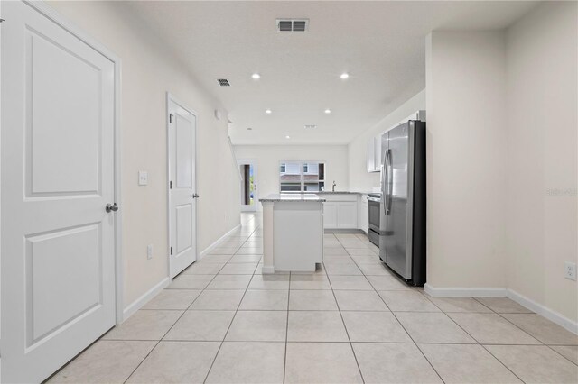 275 Blueberry Ln, Davenport, FL 33837 - kitchen with appliances with stainless steel finishes, white cabinetry, light tile patterned flooring, recessed lighting, and light countertops