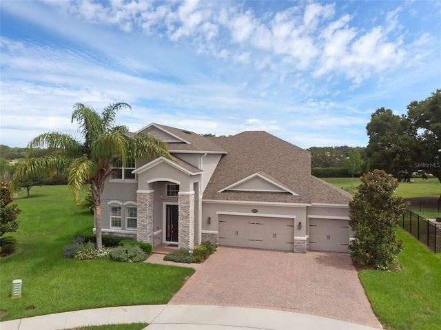 32004 Redtail Reserve Blvd, Sorrento, FL 32776 - view of front of home featuring a garage, decorative driveway, stone siding, stucco siding, and roof with shingles