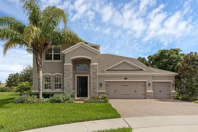 32004 Redtail Reserve Blvd, Sorrento, FL 32776 - view of front of property with stucco siding, stone siding, a garage, and decorative driveway