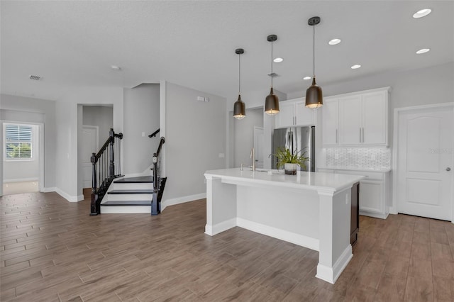 32004 Redtail Reserve Blvd, Sorrento, FL 32776 - kitchen with freestanding refrigerator, wood finished floors, a kitchen island with sink, decorative backsplash, and recessed lighting