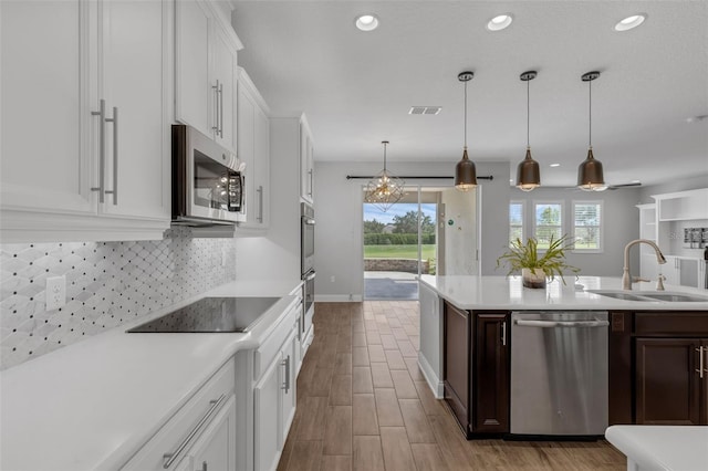32004 Redtail Reserve Blvd, Sorrento, FL 32776 - kitchen featuring appliances with stainless steel finishes, light countertops, white cabinets, tasteful backsplash, and recessed lighting