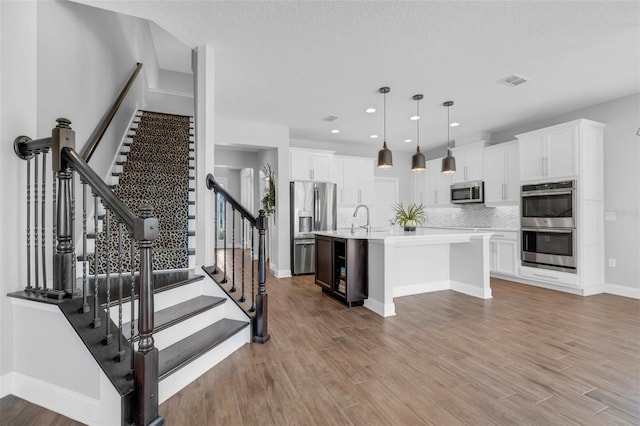 32004 Redtail Reserve Blvd, Sorrento, FL 32776 - kitchen featuring stainless steel appliances, light countertops, white cabinetry, light wood-type flooring, and recessed lighting