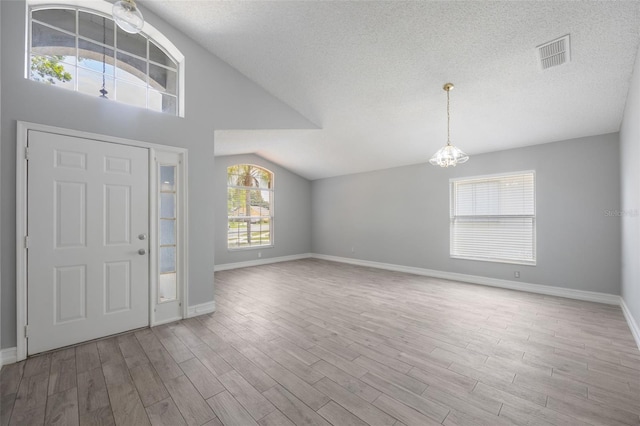 2767 Aragon Ter, Lake Mary, FL 32746 - foyer featuring a chandelier, wood finished floors, a textured ceiling, and lofted ceiling