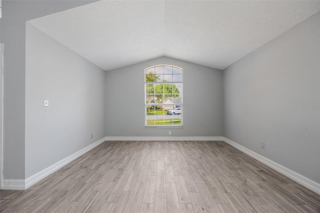 2767 Aragon Ter, Lake Mary, FL 32746 - unfurnished room with light wood finished floors, lofted ceiling, and a textured ceiling