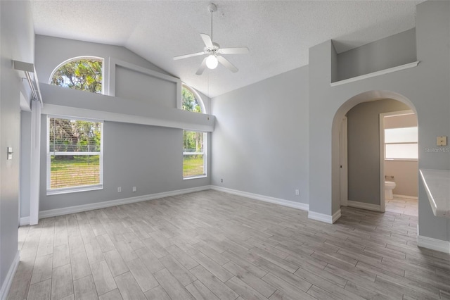 2767 Aragon Ter, Lake Mary, FL 32746 - spare room featuring ceiling fan, a textured ceiling, wood finished floors, arched walkways, and high vaulted ceiling