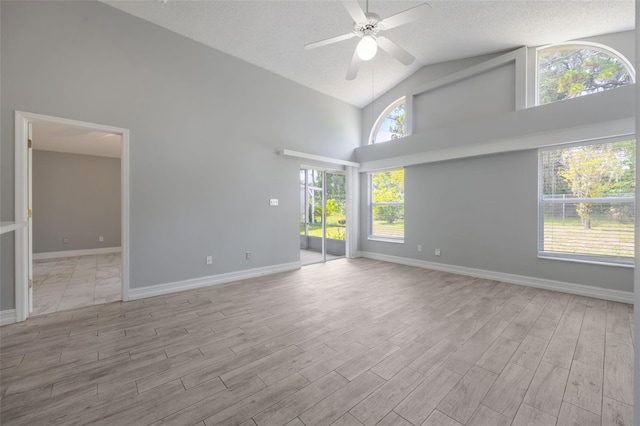 2767 Aragon Ter, Lake Mary, FL 32746 - empty room with high vaulted ceiling, wood finished floors, a ceiling fan, and a textured ceiling