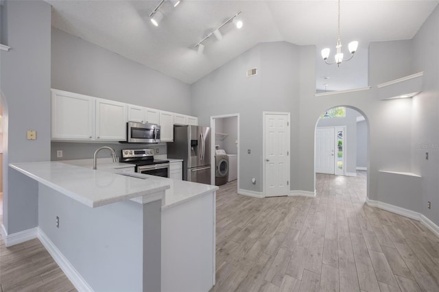 2767 Aragon Ter, Lake Mary, FL 32746 - kitchen featuring appliances with stainless steel finishes, washer / dryer, arched walkways, track lighting, and high vaulted ceiling