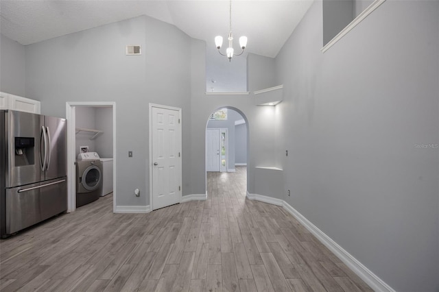 2767 Aragon Ter, Lake Mary, FL 32746 - kitchen with stainless steel fridge, washer / clothes dryer, arched walkways, light wood-style flooring, and white cabinetry