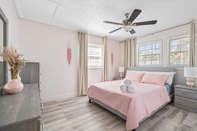 4311 123rd St W, Cortez, FL 34215 - bedroom with light wood-type flooring, a ceiling fan, attic access, and a textured ceiling