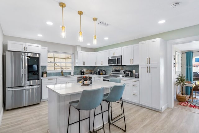 4311 123rd St W, Cortez, FL 34215 - kitchen featuring appliances with stainless steel finishes, light countertops, white cabinets, light wood-type flooring, and recessed lighting