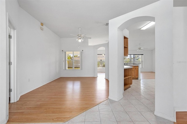 710 Independence Dr, Orange City, FL 32763 - unfurnished living room with arched walkways, a ceiling fan, and plenty of natural light